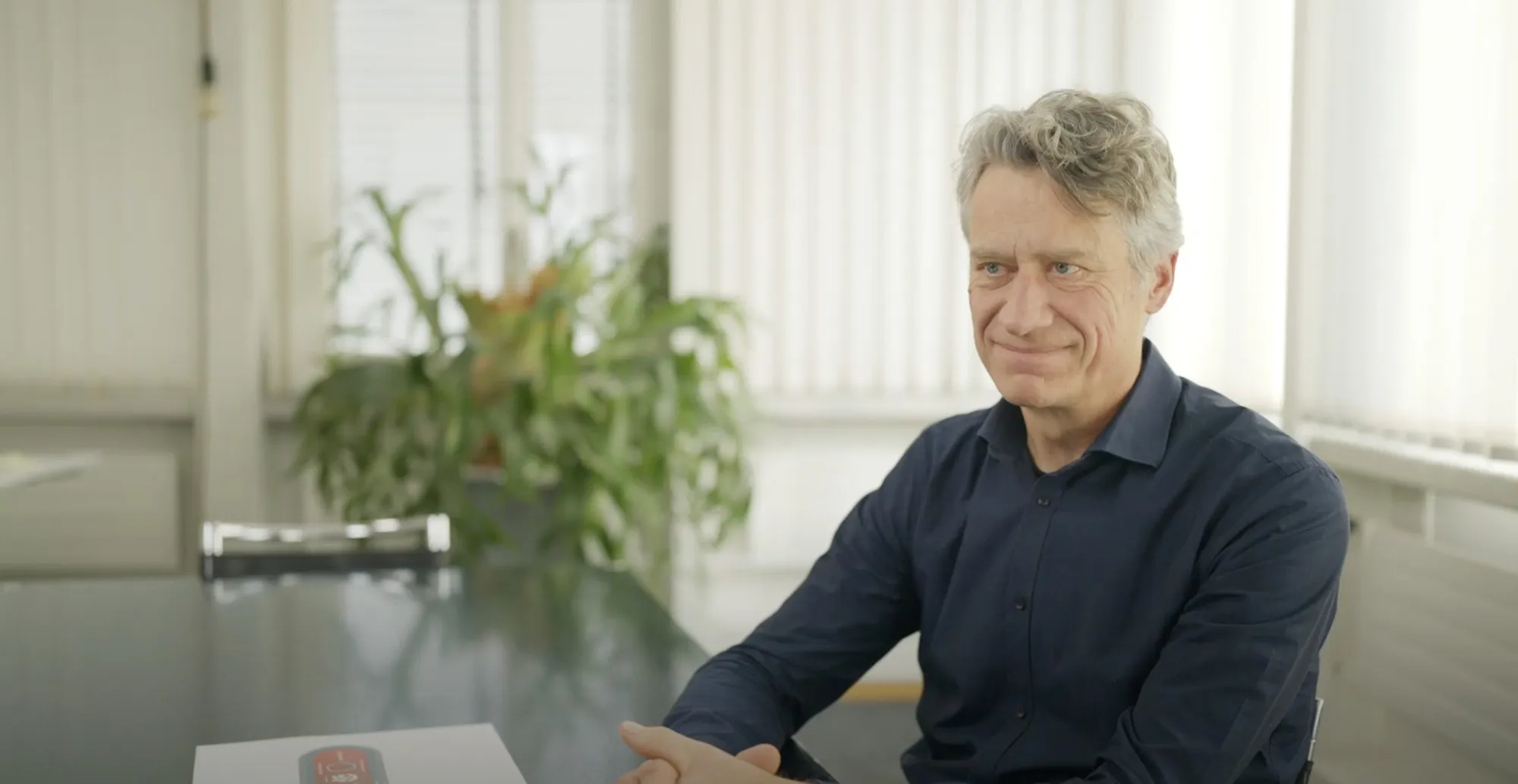 Christian Ryser sitzt an einem Tisch in einem Interviewsetting