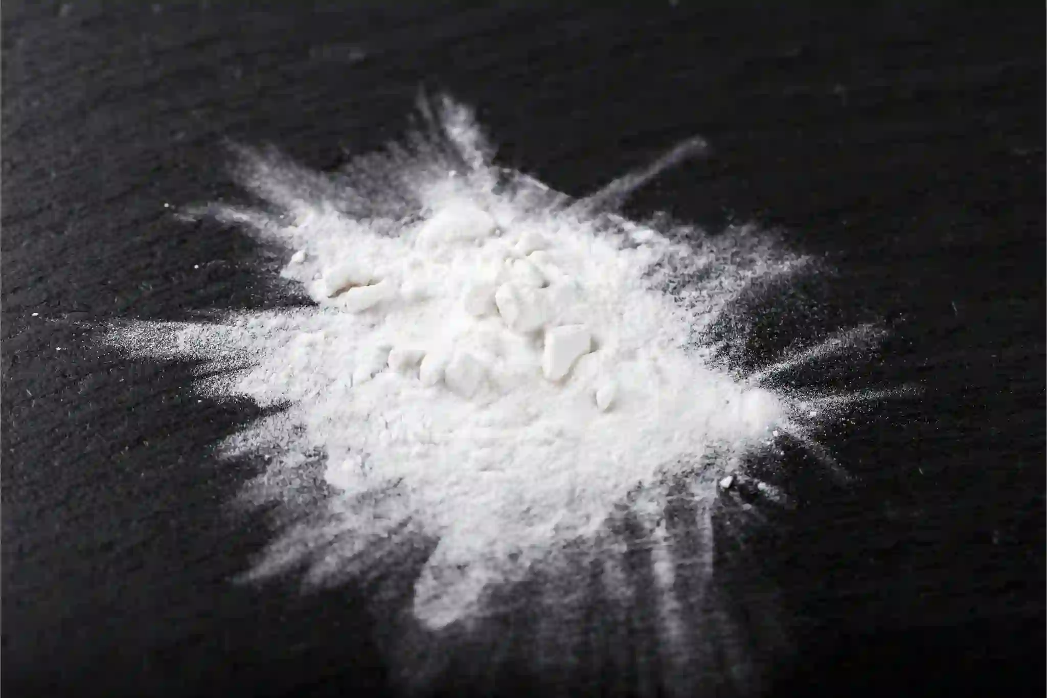 weisses Pulver auf schwarzem Tisch